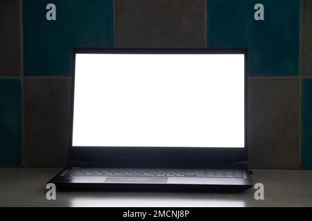 laptop with white screen stands at work place on table at home, laptop on table, white screen Stock Photo