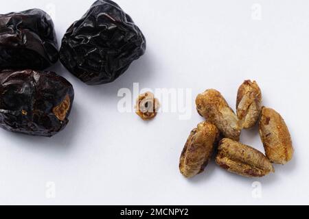 A macro shot of Ajwa type dates with seeds on a white background Stock Photo