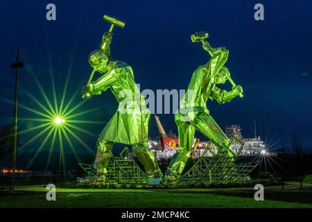 Greenock, United Kingdom. 21 January, 2023 Pictured: The Shipbuilders of Port Glasgow sculpture by John McKenna is illuminated in front of the Glen Sannox Ferry being built at the Ferguson Shipyard. Credit: Rich Dyson/Alamy Live News Stock Photo