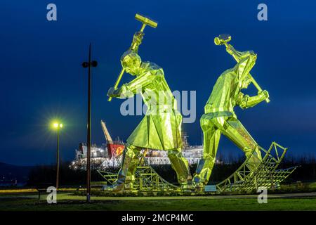 Greenock, United Kingdom. 21 January, 2023 Pictured: The Shipbuilders of Port Glasgow sculpture by John McKenna is illuminated in front of the Glen Sannox Ferry being built at the Ferguson Shipyard. Credit: Rich Dyson/Alamy Live News Stock Photo