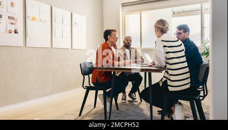 Group of creative businesspeople brainstorming during a meeting in a modern office. Diverse designers having a discussion while working together on a Stock Photo