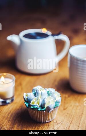 Various cupcakes decorated with colorful flower icing on wooden table, floral bouquet, wedding cake, High tea, Holiday concept Stock Photo