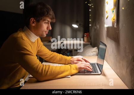 Arabic university student in dorm working on laptop at night. Copy space Stock Photo