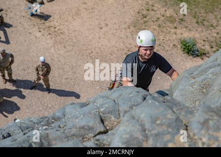 Mountaineering instructor from Northern Warfare Training Center Staff Sgt. Jordan Weeg ascends a rock face during Advanced Military Mountaineering Course 8 July at Black Rapids Training Site. The purpose of the 14-day course is to train Soldiers on how to maneuver through mountainous terrain and then go back to their units and provide the techniques and procedures to get across the mountainous terrain of Alaska. (Photo provided by Staff Sgt. Christopher Dennis/ 11th Airborne Division Public Affairs NCO) Stock Photo