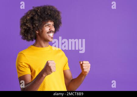 Happy african man celebrating raising the fists Stock Photo