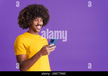 Happy african man smiling while using a mobile Stock Photo