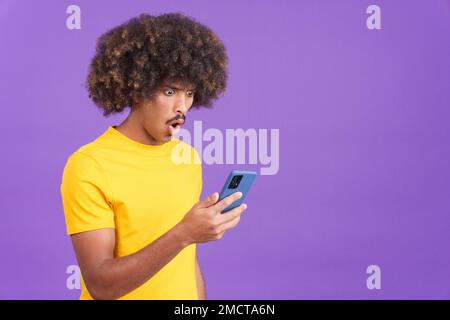 Surprised african man looking the screen of a mobile Stock Photo