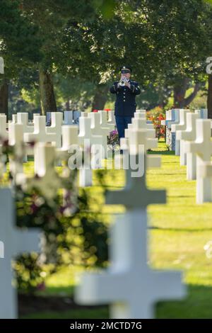 Sgt. Nathaniel Patty, bugler, U.S. Army Europe and Africa Band & Chorus, plays Taps during a burial ceremony for U.S. Army Air Forces 2nd Lt. William J. McGowan at Normandy American Cemetery, France, on July 9, 2022.     McGowan was killed during operations in France during World War II nearly 80 years ago. He was laid to rest with full military honors with family, friends and local officials in attendance. He was interred approximately 350 miles away from his uncle and namesake, who died during World War I and is buried at the Meuse-Argonne American Cemetery, France.    Prior to his identific Stock Photo