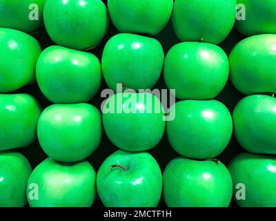 Green apples called granny smith arranged in stack for sale. Green apples pattern. Close up view. Modern color. Stock Photo
