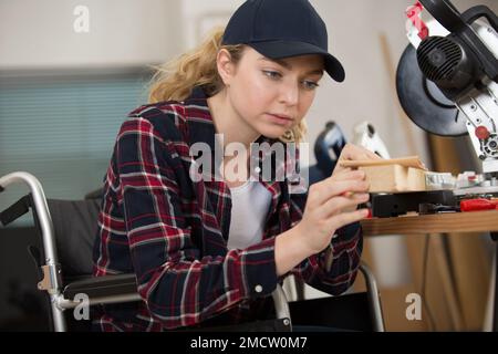 disabled female worker in wheelchair in a carpenters workshop Stock Photo