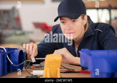 female technician wiring cables into chocolate box Stock Photo