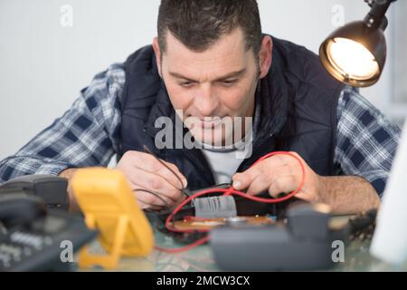 engineer using multimeter to test telephone handset Stock Photo