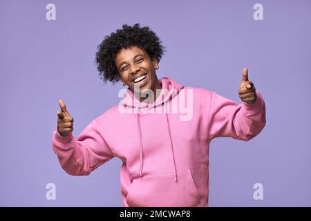 Happy African American teen guy pointing at you isolated on purple background. Stock Photo
