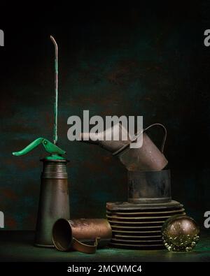 Gardening theme, weeds, still life with old oil cans, glass ball and old motorbike cylinder, studio shot, symbol photo Stock Photo