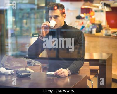 Man Drinking Coffee from Outside of the Bar Window Stock Photo