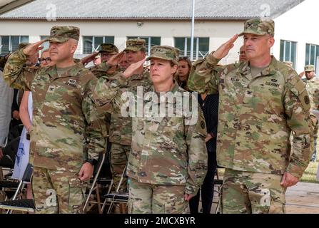 From left to right:  U.S. Army Col.  Joshua D. Hirsch, outgoing 598th Transportation Brigade, Surface Deployment and Distribution Command commander, Maj. Gen. Heidi J. Hoyle, commanding general of Military Surface Deployment and Distribution Command and Col. Robert L. Kellam incoming 598th Transportation Brigade, Surface Deployment and Distribution Command commander, render honors while the German and American National Anthem play at a change of command ceremony, July 11, 2022, at Daenner Kaserne, Kaiserslautern, Germany. The 598th TBDE executes mission command for strategic seaport operations Stock Photo