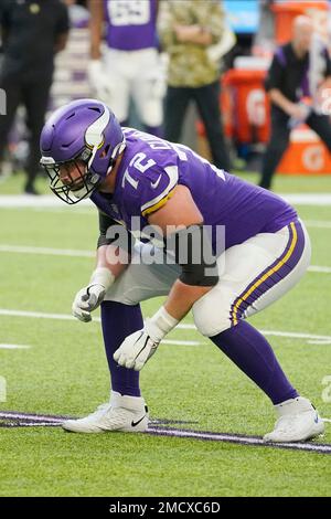 Minnesota Vikings guard Ezra Cleveland (72) talks with quarterback Kirk  Cousins (8) while participating in drills