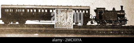 A 1930 extra miniature railway train - Scale 2mm to the foot - showing its size compared to  a postage stamp. Stock Photo