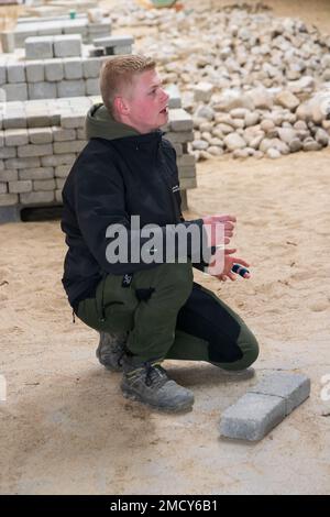 Aarhus, Denmark - November 16, 2022: Student presenting the Instruction hall of a vocational school with heaps of bricks for all kinds of practical paving instructions and training Stock Photo