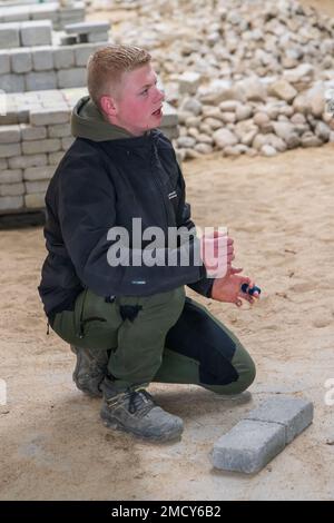 Aarhus, Denmark - November 16, 2022: Student presenting the Instruction hall of a vocational school with heaps of bricks for all kinds of practical paving instructions and training Stock Photo