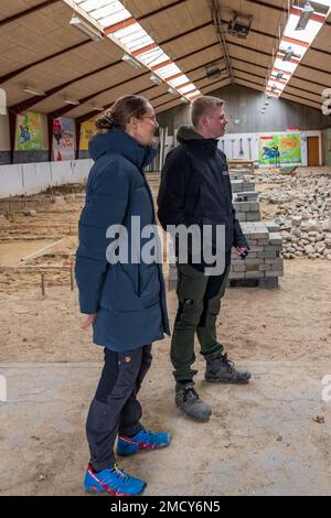 Aarhus, Denmark - November 16, 2022: Students presenting the Instruction hall of a vocational school with heaps of bricks for all kinds of practical paving instructions and training Stock Photo