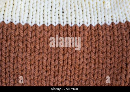 Hand knitted plaid. Geometric seamless knitted pattern. The texture is knitted. Knitting. White and brown knitted background Stock Photo