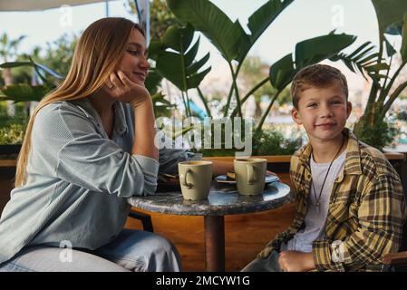 Cheese cake and coffee. Mother and son having lunch at cafe. Stock Photo