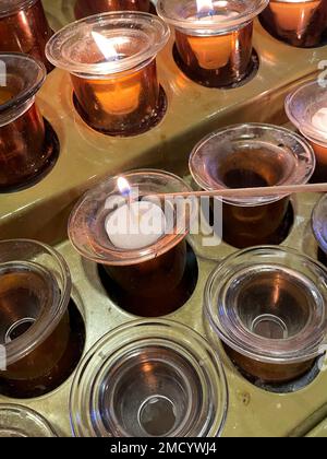 Votive candles are lit in the Catholic Church as a sign of devotion, and an offering, 2023, USA Stock Photo