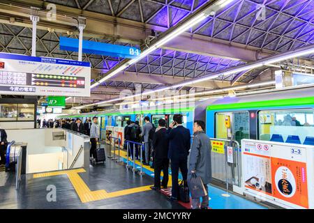 Tokyo Hamamatsucho station interior. Tokyo monorail train at the platform about to depart for Haneda International Airport. People queuing to board. Stock Photo