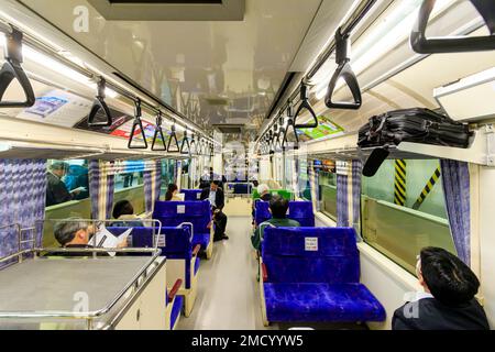 Tokyo monorail. Interior of the Hamamatsucho airport connection train to Haneda International Airport. People sitting in carriage while in station. Stock Photo