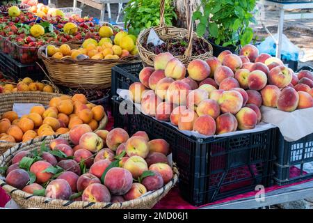 Brightly Coloured Fresh Fruit Displayed on a Weekly Market Stall, Baia Sardinia, Gallura, Sardinia, Italy. Stock Photo
