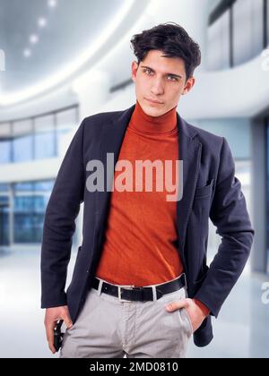 Handsome young male worker in office building, standing Stock Photo
