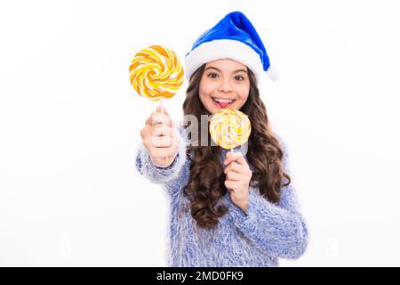 Winter teen girl hold christmas lollipop. Merry christmas. Teen girl on christmas background. Studio portrait of christmas teenager girl. Stock Photo