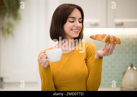 Joyful young lady having breakfast at home Stock Photo