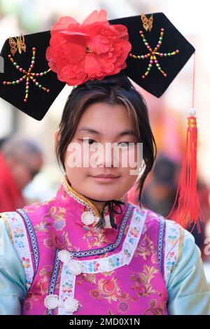 A woman of Chinese origin dressed in a traditional costume during the Chinese New Year parade celebration in Madrid. With more than 4,000 years of antiquity, it is the most important festivity of the Asian country and this year the protagonist will be the rabbit, an animal that represents peace, kindness and hope. China celebrates its New Year by following its own horoscope, which is governed by the phases of the moon, not the Gregorian calendar, so the yearly start date changes. The epicenter is the Usera district, which brings together the largest Chinese community in Madrid. Stock Photo