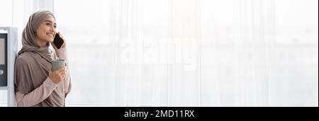 Ad Banner. Smiling Muslim Woman Talking On Cellphone In Office, Wide Shot Stock Photo