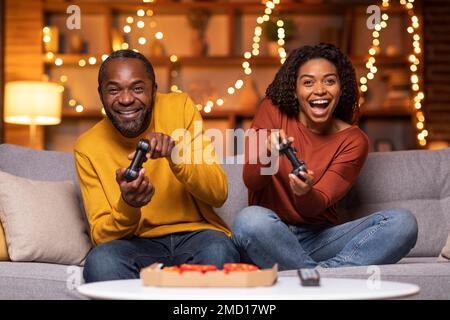 Emotional black couple playing video games at home Stock Photo