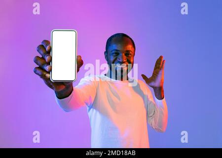 Happy black man showing smartphone and gesturing, mockup Stock Photo