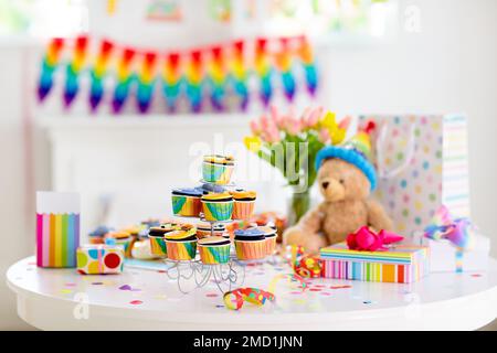 Cupcakes for kids birthday celebration. Jungle animals theme children party. Decorated room for boy or girl kid birthday. Table setting with presents Stock Photo