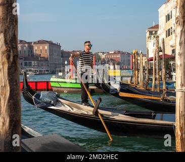 October 31, 2022 - Venice, Italy: Gondolier standing in a gondola. Tourism concept. Stock Photo
