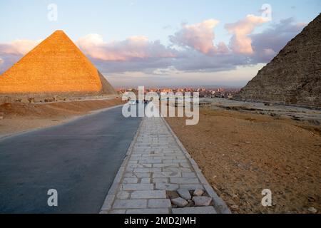 Top part of the highest Giza pyramid of Khufu or Cheops and Cairo city behind Stock Photo