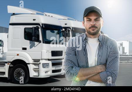 Truck driver standing in front of trucks Stock Photo
