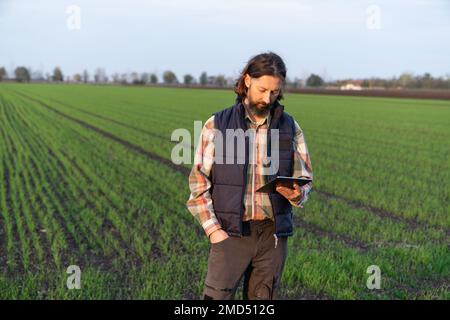 Farmer with digital tablet on a field. Smart farming and digital agriculture Stock Photo