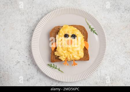 Funny toast with scrambled eggs in a shape of chicken Stock Photo