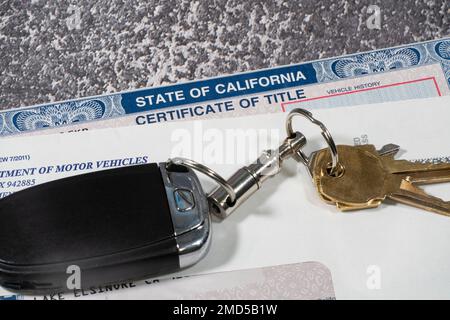 Lake Elsinore, California, USA- January 22, 2023: Close up of automibile certificate of title in envelope with keys. Stock Photo