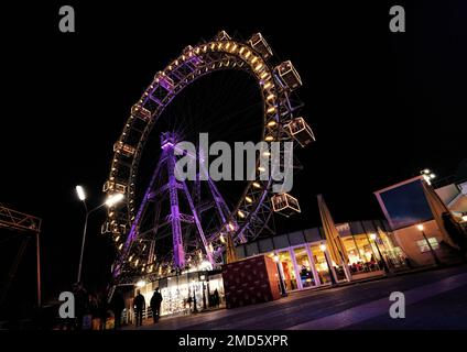Vienna, Austria, Dec. 2019: View of popular Ferris wheel with colorful illuminated rim at night in amusement park Prater (Wurstelprater) Stock Photo