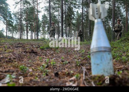 Finnish soldiers assigned to Satakunta Jaeger Battalion and U.S. Soldiers assigned to the 4th Squadron, 10th Cavalry Regiment, 3rd Armored Brigade Combat Team, 4th Infantry Division, look for simulated explosive ordnance scattered across the ground during Finnish unexploded ordnance and mine awareness training at Säkylä, Finland, July 14, 2022. The 3rd Armored Brigade Combat Team, 4th Infantry Division, and the Pori Brigade of the Finnish army began summer training in Finland to strengthen relations and help build interoperability between the two nations. Stock Photo