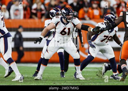 Denver Broncos guard Graham Glasgow (61) runs onto the field next to a  member of the military before an NFL football game between the Broncos and  the Las Vegas Raiders in Denver