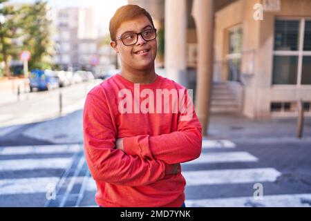 Down syndrome man smiling confident standing with arms crossed gesture at street Stock Photo