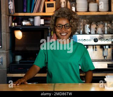 Portrait of a smiling African American woman waitress with afro hair in a pub Stock Photo